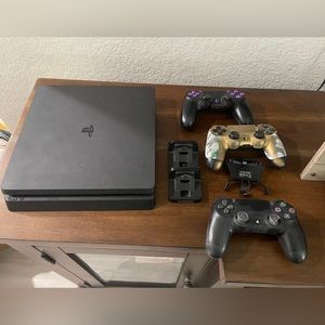 PS4 Slim with controllers, charging base, and collective mind strike pack.